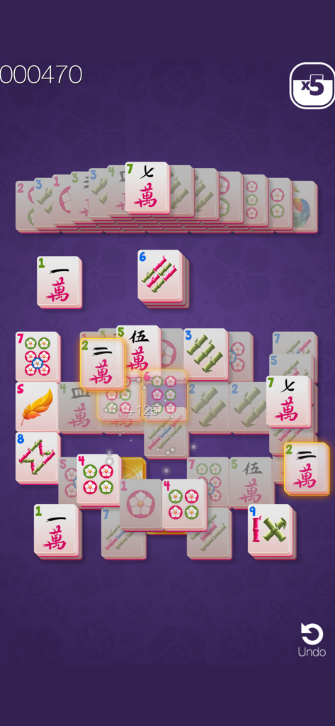 Gameplay screen of Gold Mahjong solitaire featuring traditional tile matching on a purple floral background