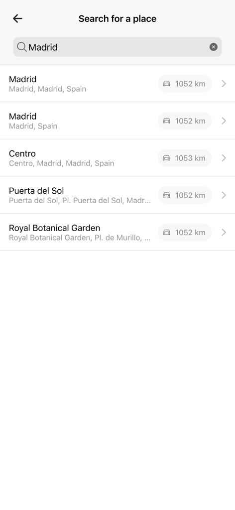 Curiocity app search screen showing results for Madrid Spain including Puerta del Sol and the Royal Botanical Garden with distances