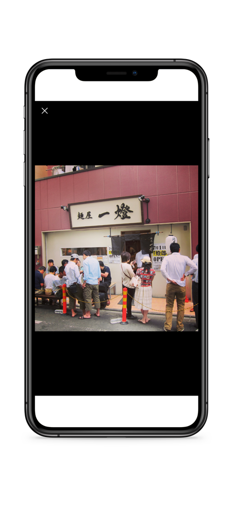 People waiting in line outside a traditional ramen shop in Tokyo.