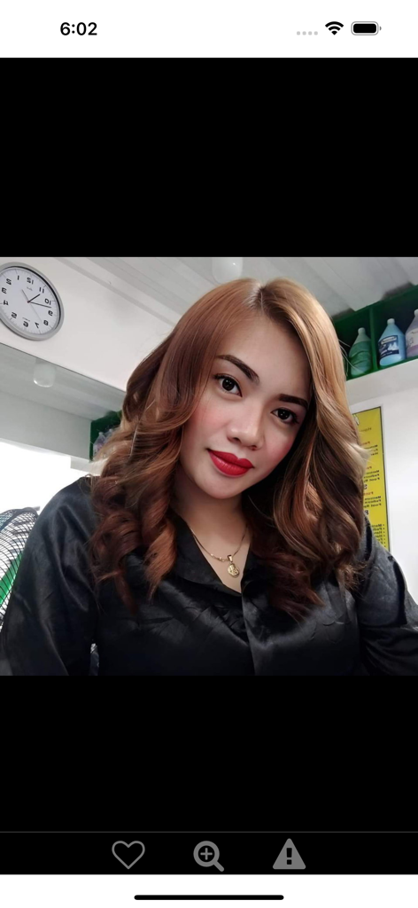 Portrait of a beautiful Southeast Asian woman with wavy brown hair and red lipstick on the Ladyboykisses dating app