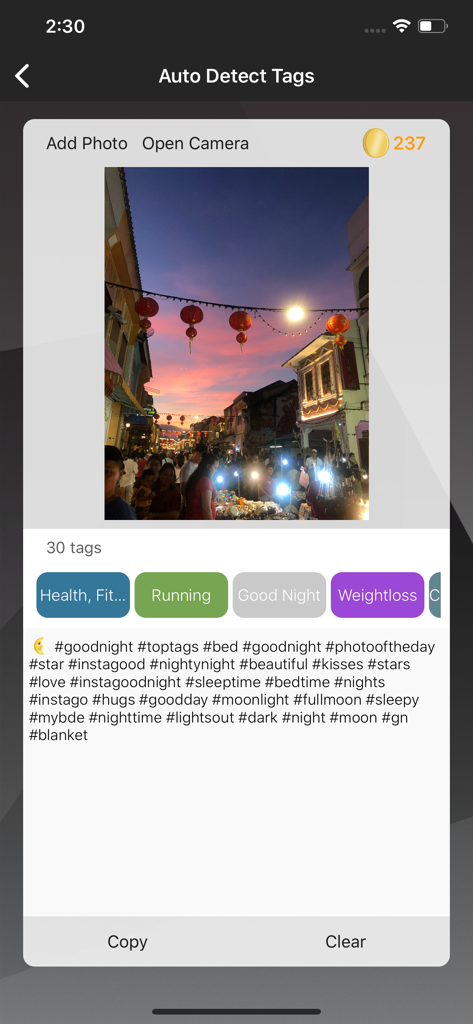 Top Tagsアプリで夕暮れのストリートマーケットの写真に対して自動検出されたハッシュタグを表示するインターフェース
