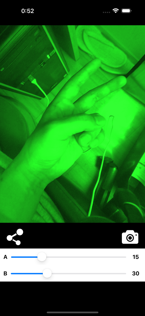 Green night vision camera filter effect on a photo showing a hand gesture and app controls