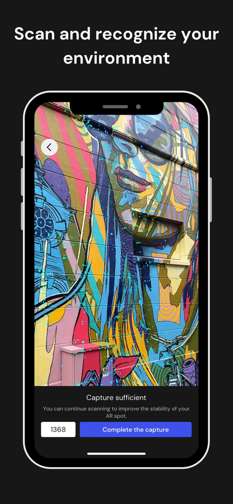 Wintor AR Tours - A smartphone using the Wintor AR Tours app to scan a colorful wall mural for environment recognition and AR spot creation.