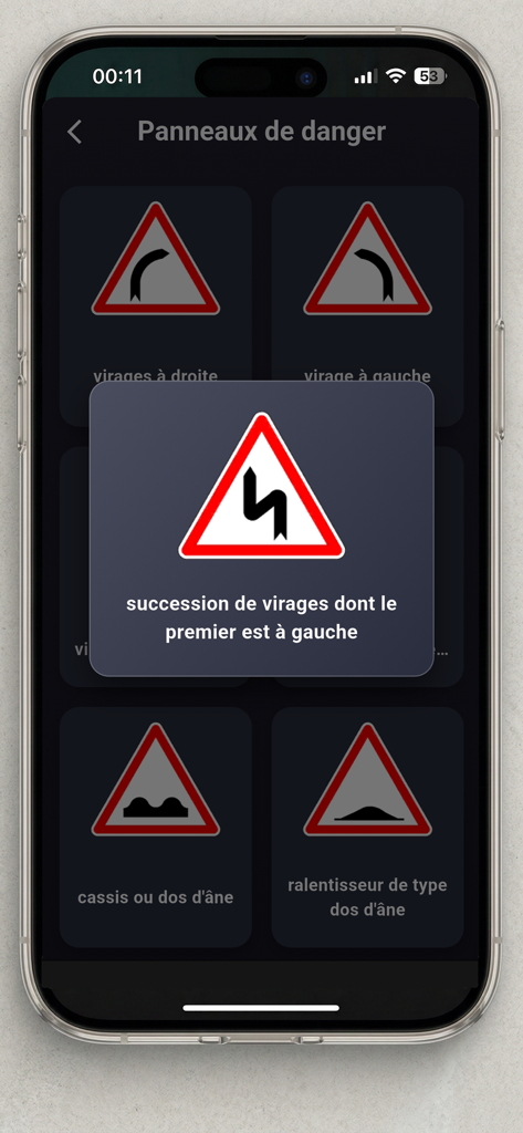 Code Moto ETM - Permis A A1 A2 - Écran de l'application de théorie moto française montrant les panneaux de danger routier et une fenêtre contextuelle détaillée décrivant un avertissement de route sinueuse.
