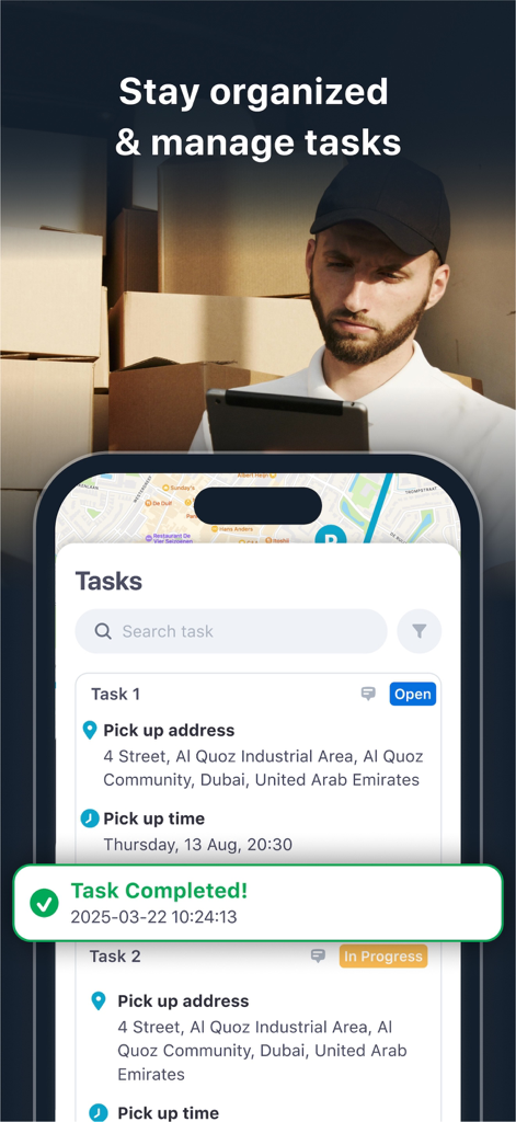 Un hombre en un almacén usando la interfaz de gestión de tareas de la aplicación Track My Phone GPSWOX en un smartphone