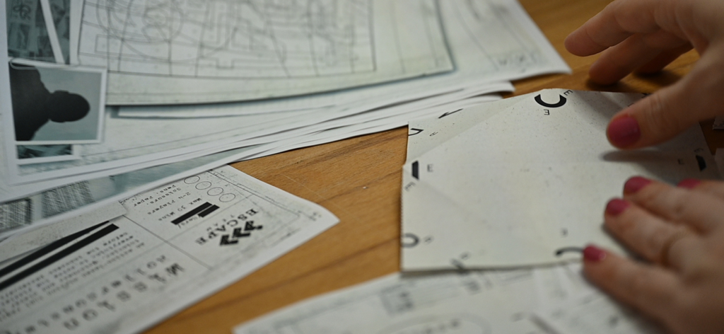 Escape Team MDM - Hands interacting with printed paper puzzles for the Escape Team MDM game