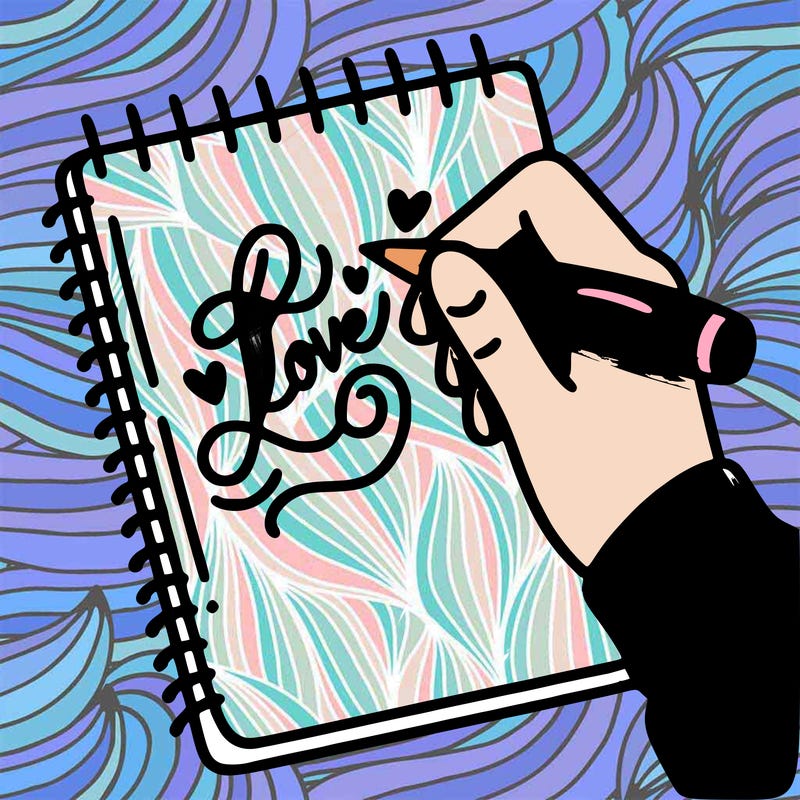 a hand writing “love” in calligraphy on a notebook