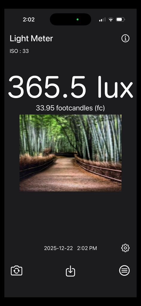 Light Meter - Brightness Calc - Interface of the Light Meter app displaying lux and footcandle measurements with a forest scene photo.