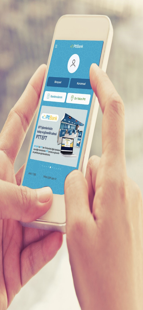 A person holding a smartphone displaying the PTTBank mobile application interface with Turkish banking options for individual and corporate users