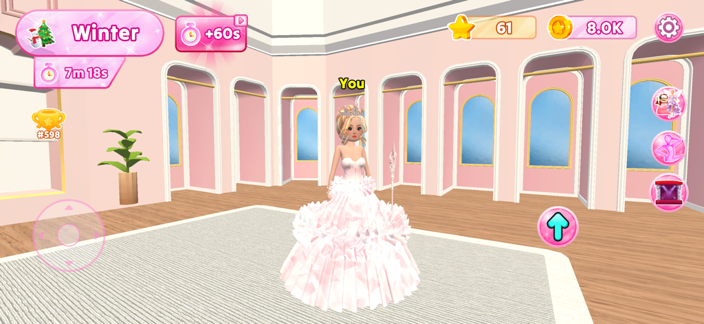 Dress Up Fashion Star - Un personaje 3D vistiendo un vestido de princesa blanco con volantes y una corona en un estudio rosa para un desafío de moda de invierno.