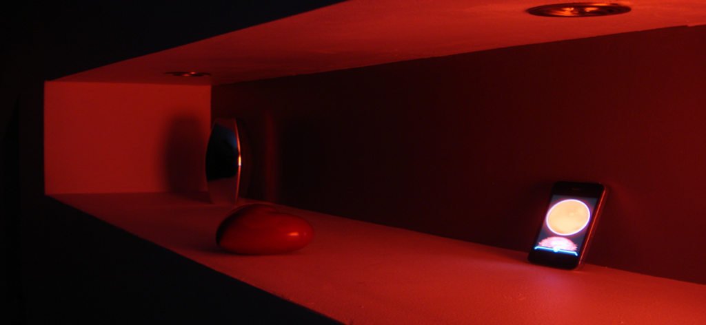 Um iPhone usando o aplicativo Mood Colors para criar uma luz ambiente vermelha em uma prateleira.