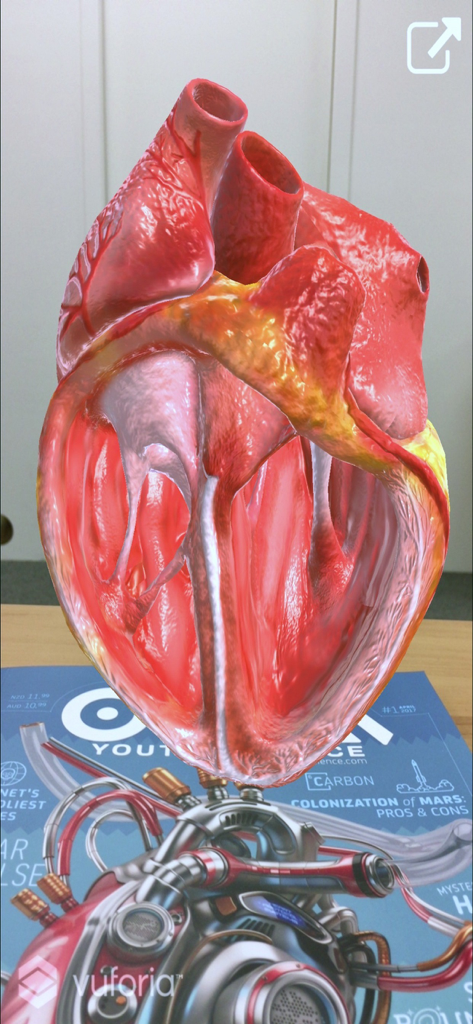 OYLA Science AR - A 3D augmented reality model of a human heart floating above an OYLA science magazine