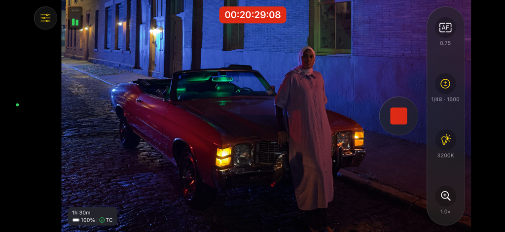 Final Cut Camera - Final Cut Camera 앱 인터페이스로, 붉은 자동차와 함께 시네마틱 야간 영상 촬영을 위한 노출 및 포커스용 전문가용 수동 제어 기능 표시