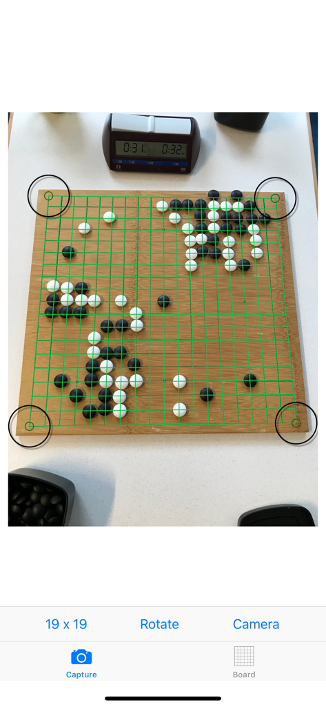 Baduk Cap - Baduk Cap app performing image recognition on a physical wooden Go board with a green grid overlay