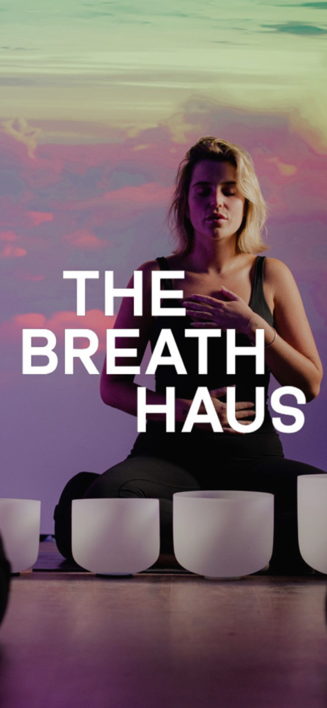 A woman meditating with singing bowls on the splash screen of The Breath Haus wellness app