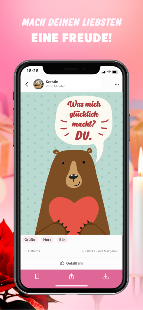 Congratulations Videos & Pics - A mobile phone displaying a digital greeting card from the app featuring a cute brown bear holding a red heart with a loving message in German