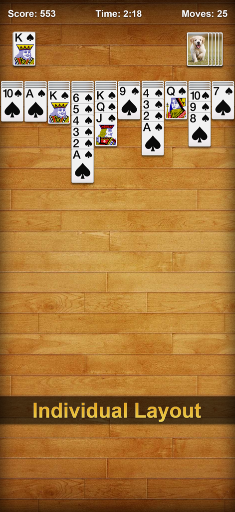 Classic Spider Solitaire gameplay showing the individual layout feature with puppy card backs on a wood background