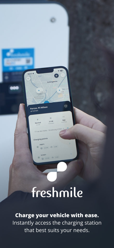 Freshmile – Charge points - A person using the Freshmile app on a smartphone to find a nearby electric vehicle charging station