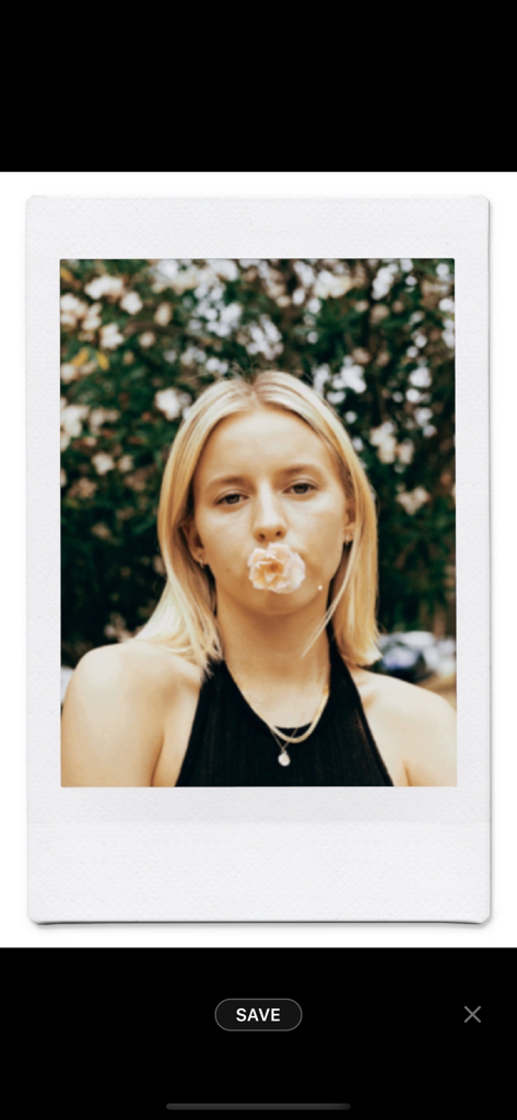 Retrato em filme vintage de uma mulher com uma flor na boca, dentro de uma moldura de foto instantânea.