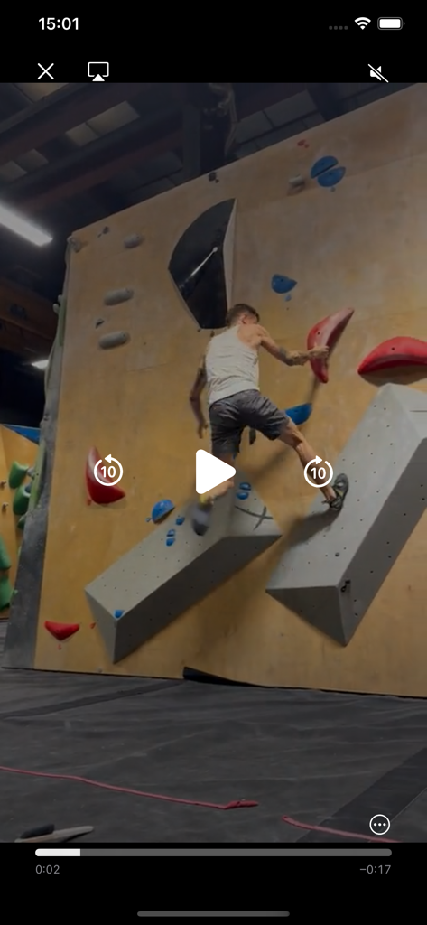 SocialBoulder - Un homme fait du bloc sur un mur d'escalade intérieur dans l'interface du lecteur vidéo SocialBoulder