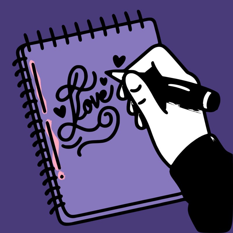 a hand writing “love” in calligraphy on a notebook