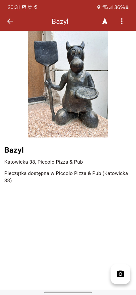 A bronze sculpture of a Bebok named Bazyl holding a pizza and a bakers peel at Piccolo Pizza and Pub