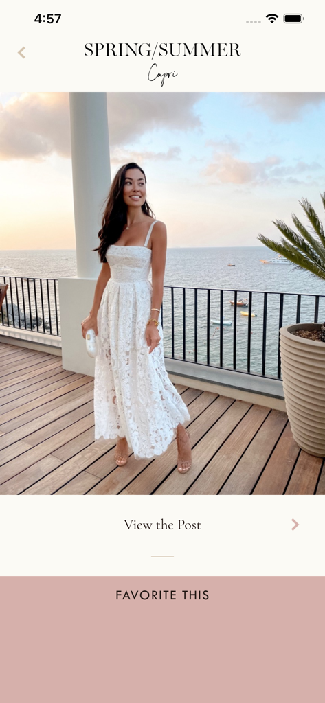 With Love From Kat Travel - カプリ島のテラスで、海を見下ろしながら白いレースのドレスを着たおしゃれな女性。