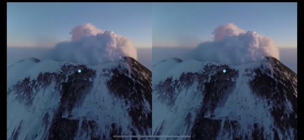 A split screen virtual reality view of a snowy mountain peak emitting smoke