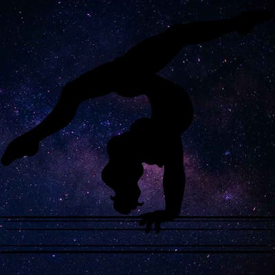 gymnast doing split handstand on a beam