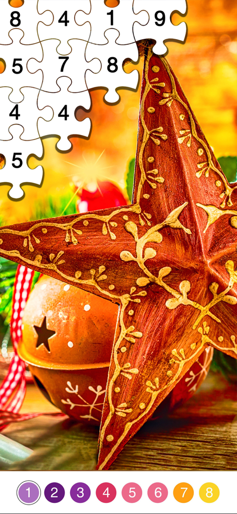 Un puzzle a colori per numero con una stella natalizia rossa festosa e un ornamento a campana dorata.