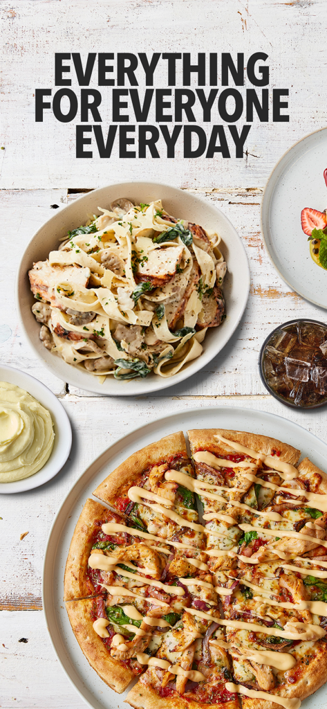 RASHAYS® - A flat lay of diverse menu items including chicken pizza, creamy pasta, and mashed potatoes on a white wooden surface