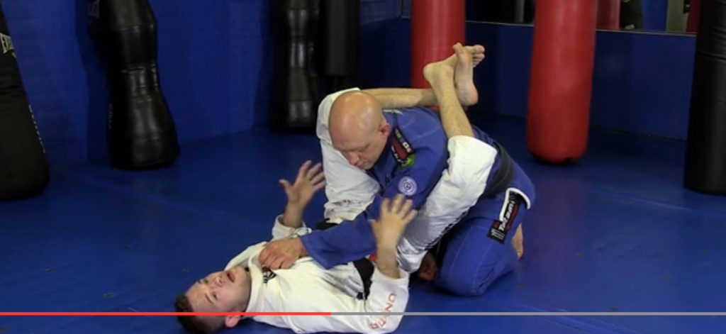 BJJ Master App by Grapplearts - Stephan Kesting demonstrating a Brazilian Jiu-Jitsu technique on a partner in a gym.