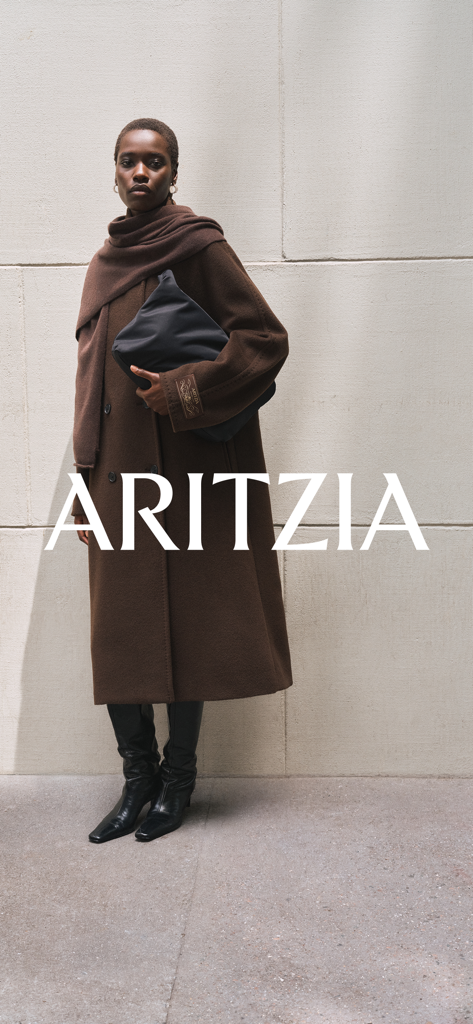 Aritzia - Una modelo usando un abrigo largo de lana marrón y una bufanda a juego con el logo de Aritzia superpuesto