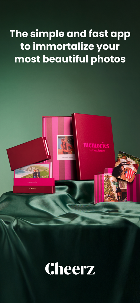 CHEERZ - Photo Printing - 緑のサテン地の上に、パーソナライズされたピンクと赤のフォトブックやメモリーボックスを含むCheerzフォト製品のコレクション。