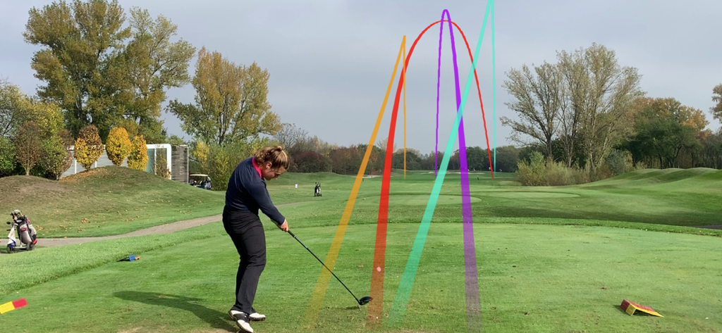 Ein Golfer auf einem grünen Abschlag mit mehreren bunten automatischen Ballflug-Tracer-Linien