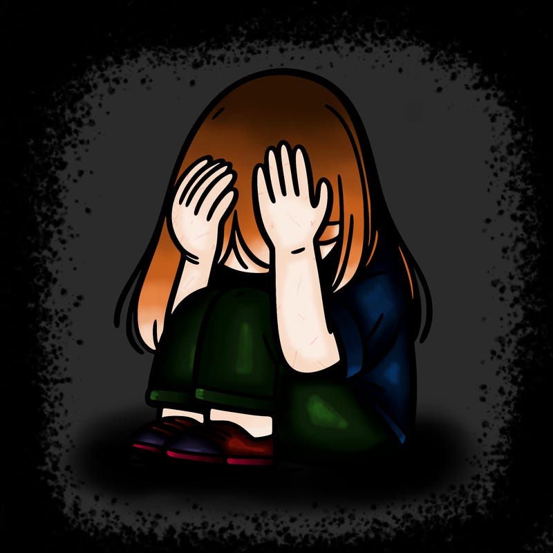 girl sitting down covering her head