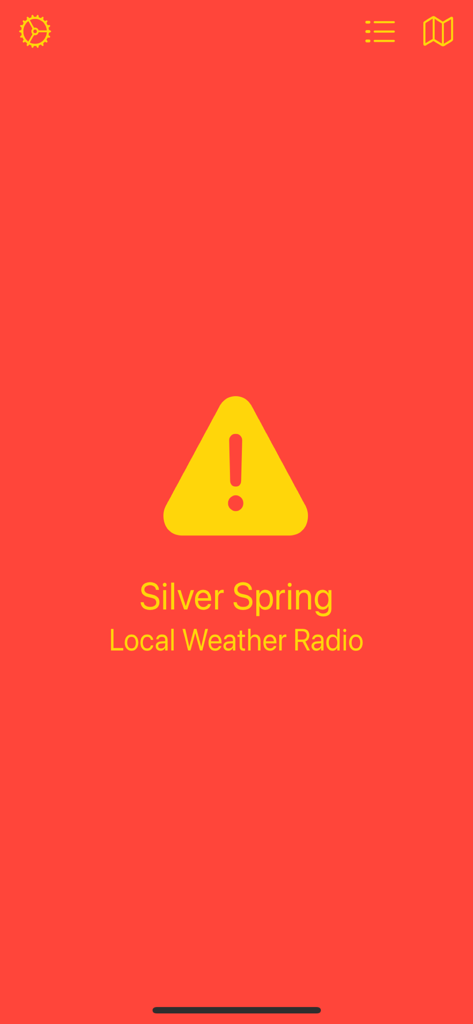 NOAA Local Weather Radio - The Silver Spring alert screen of the NOAA Local Weather Radio app featuring a yellow warning triangle on a bright red background.