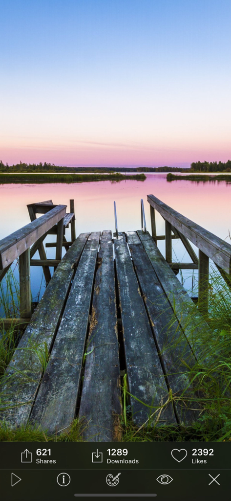 Kappboom - Cool Wallpapers - A serene nature wallpaper showing a wooden pier leading into a calm lake at sunset with pink and blue sky.