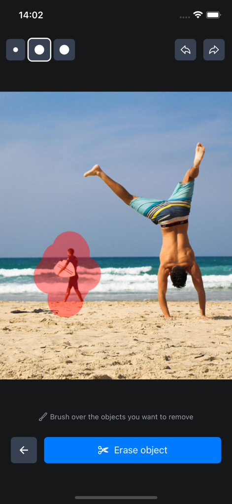 ビーチにいる人物が、AIオブジェクト消しゴムツールを使用して削除対象としてハイライトされている様子。
