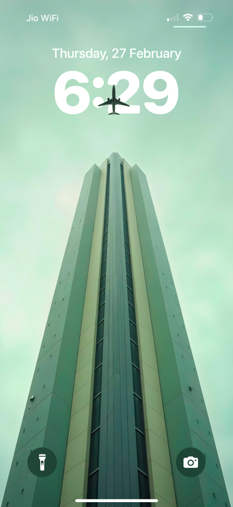 Lagguy Wallpaper Background - iPhone lock screen featuring a high-quality depth effect wallpaper of a skyscraper with an airplane flying above