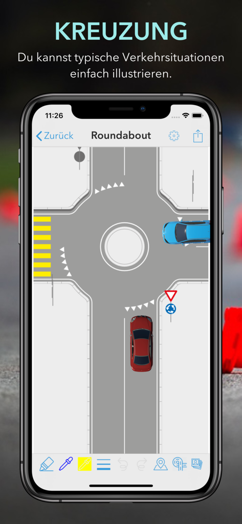 Smartphone screen showing an illustrated roundabout traffic situation diagram with blue and red cars in the iTheory DriveTrack app