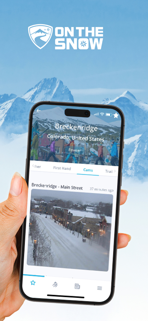 Uma mão segurando um smartphone mostrando uma visualização de webcam ao vivo de Breckenridge nevado, Colorado, no aplicativo OnTheSnow