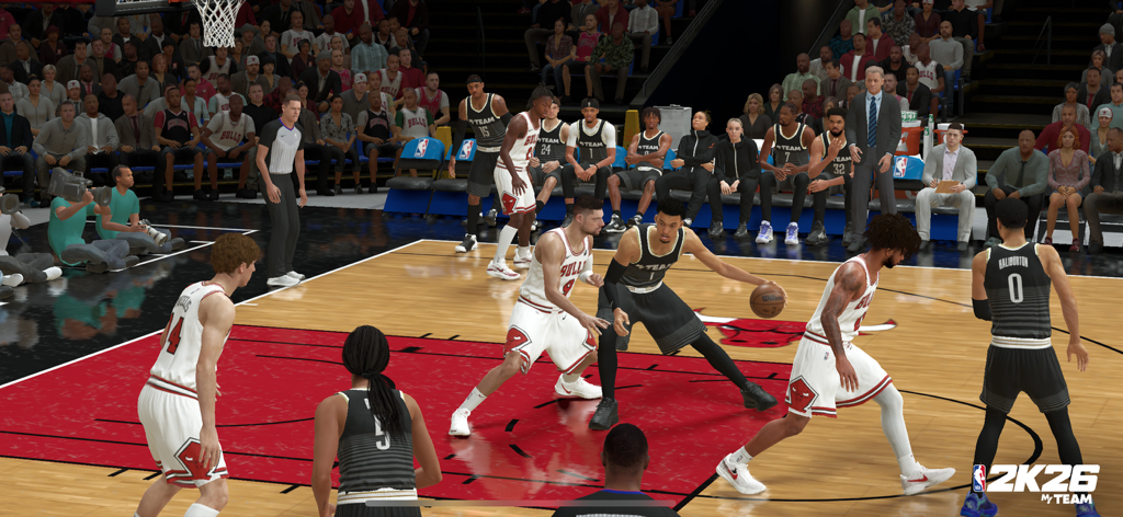 Scatto d'azione di gioco con giocatori che competono su un campo da basket professionistico in NBA 2K26 MyTEAM.