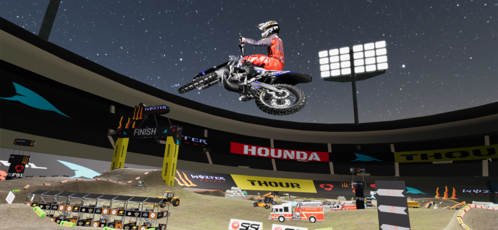 Motocross rider performing a high jump stunt in a stadium at night