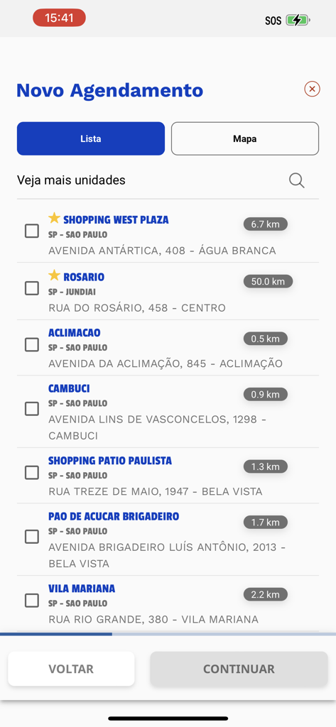 Espacolaser mobile app screen showing a list of available clinics for scheduling a new appointment with distances and addresses