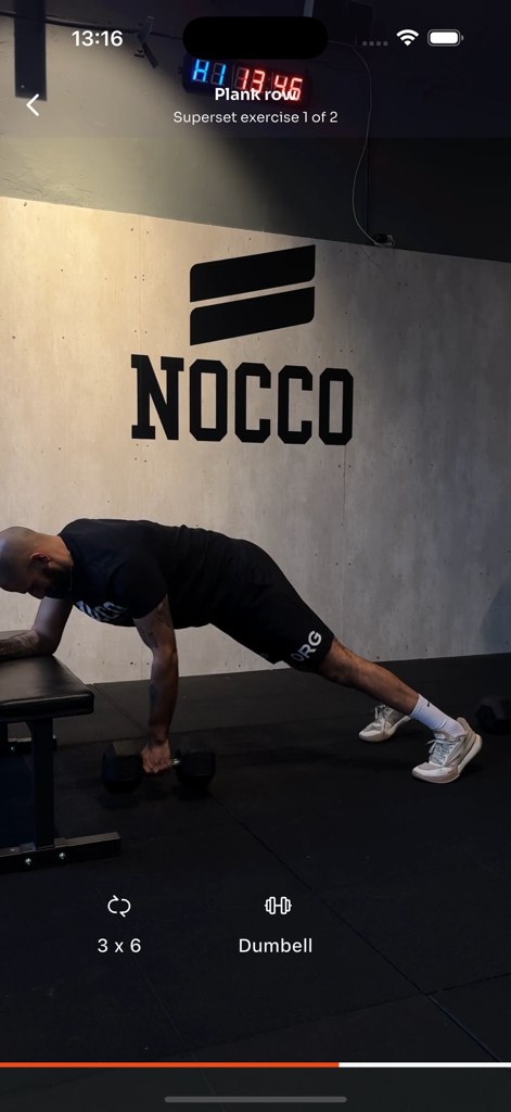 Amir Performance - A man performing a plank row exercise with a dumbbell in a gym on the Amir Performance app