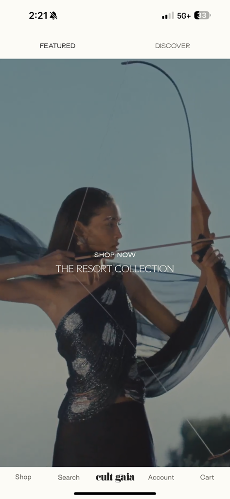 CULT GAIA - Pantalla de inicio editorial de la app Cult Gaia con una modelo con un lazo para la colección resort.