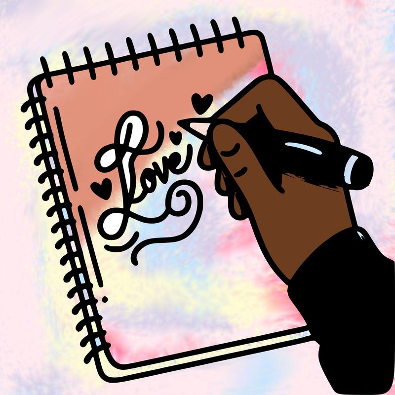 a hand writing “love” in calligraphy on a notebook