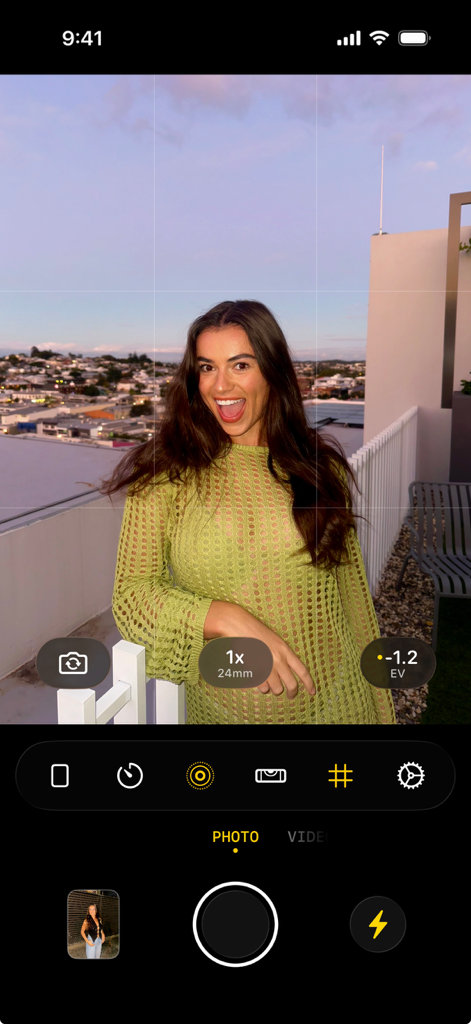 Smartphone screen showing the flag7x camera app interface with a portrait of a woman on a rooftop
