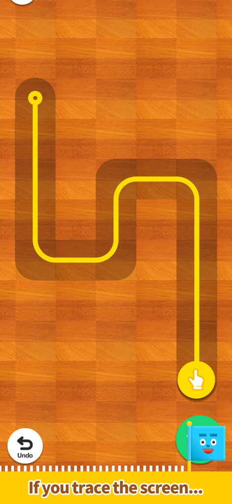 Pocket Marble Runs - 木製の床の上で黄色い道をなぞり、カスタムのマーブルランコースをデザインしている様子